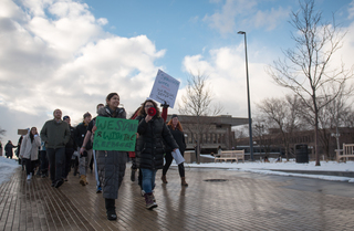 Arva Hassonjee and Nedda Sarshar lead hundreds of students down Syracuse University's promenade on Thursday in a 